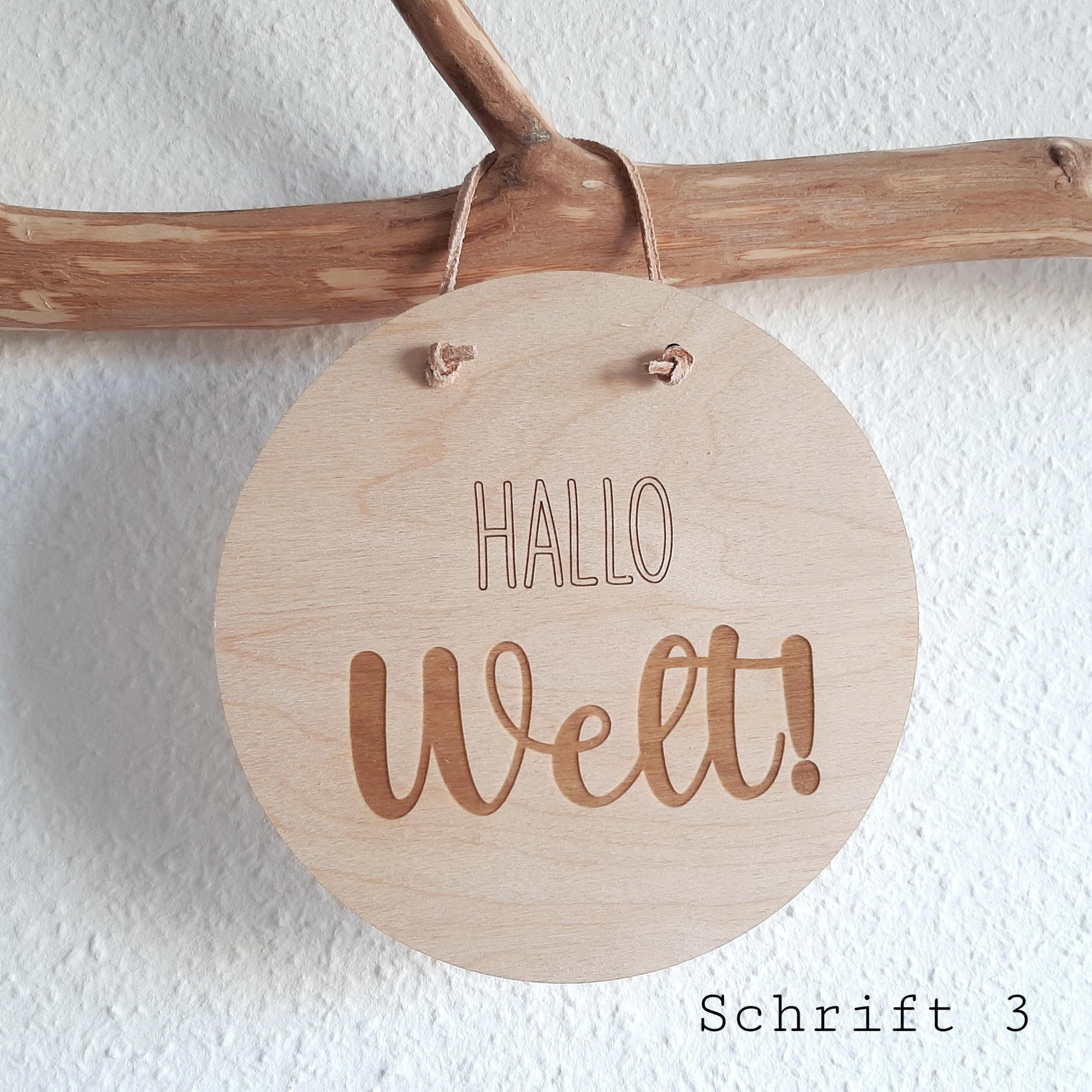 Das Türschild aus Holz hängt an einem Ast. Dabei ist die Schrift 3 zu sehen. Das ideale Geschenk zur Geburt oder zur Geschlechtsverkündung bei der Baby Party.