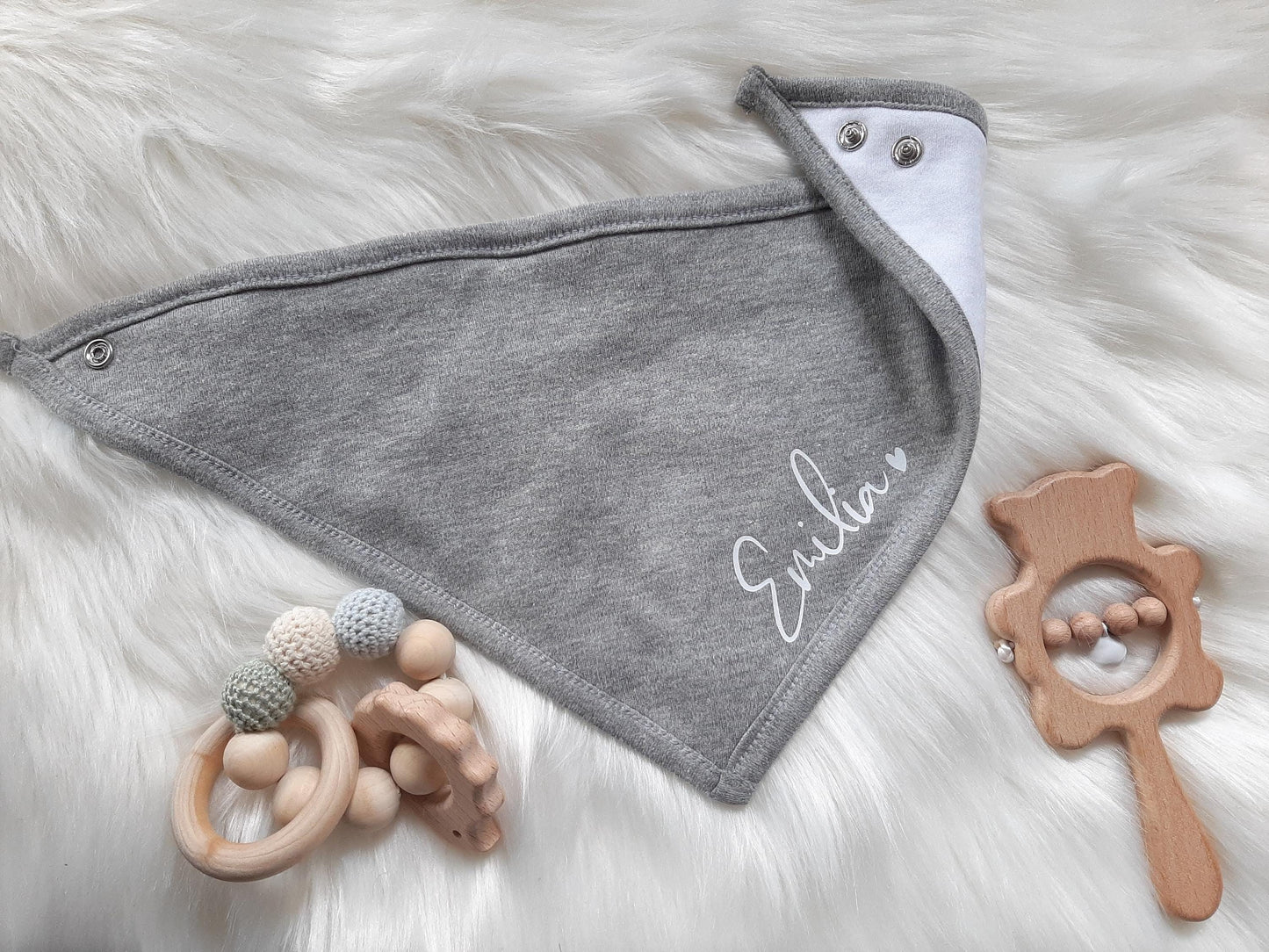 Personalisiertes Babyset: Graues Dreicktuch für Babys mit Druckknöpfen als Verschluss. Aufdruckfarbe weiß. Hinter demName ist ein Herz als Symbol draufgedruckt. Kuschelige Babykleidung und Accessoires. Süßes New Born Set. Veredelt von SelfmadeStudio