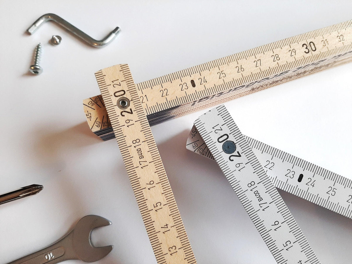 Zollstock 2 m aus Holz in Natur und Weiß mit Zentimeter-Skala, Made in Germany, neben Werkzeug