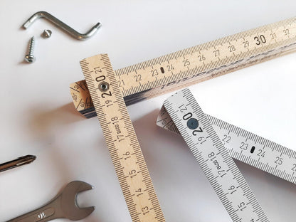 Zollstock 2 m aus Holz in Natur und Weiß mit Zentimeter-Skala, Made in Germany, neben Werkzeug